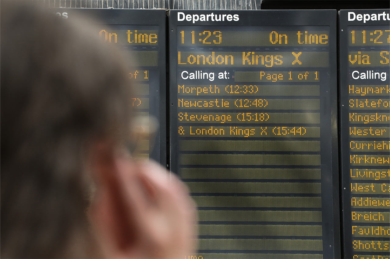 Image of a person looking at train departure board