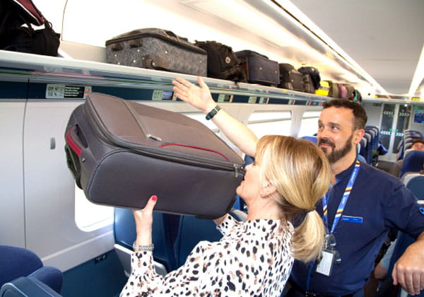woman storing luggage on lumo train