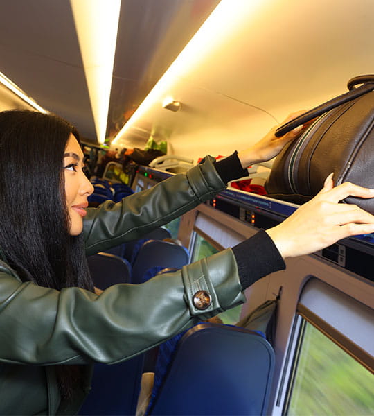 Customer storing suitcase in overhead rack