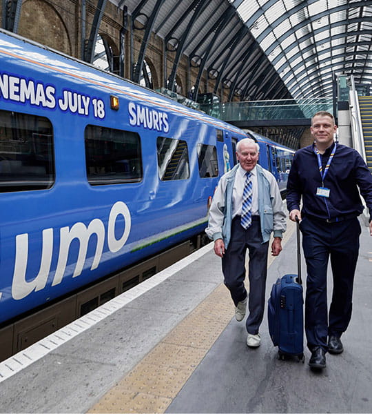 Charlie Barker and Lumo member of staff next to a Lumo train