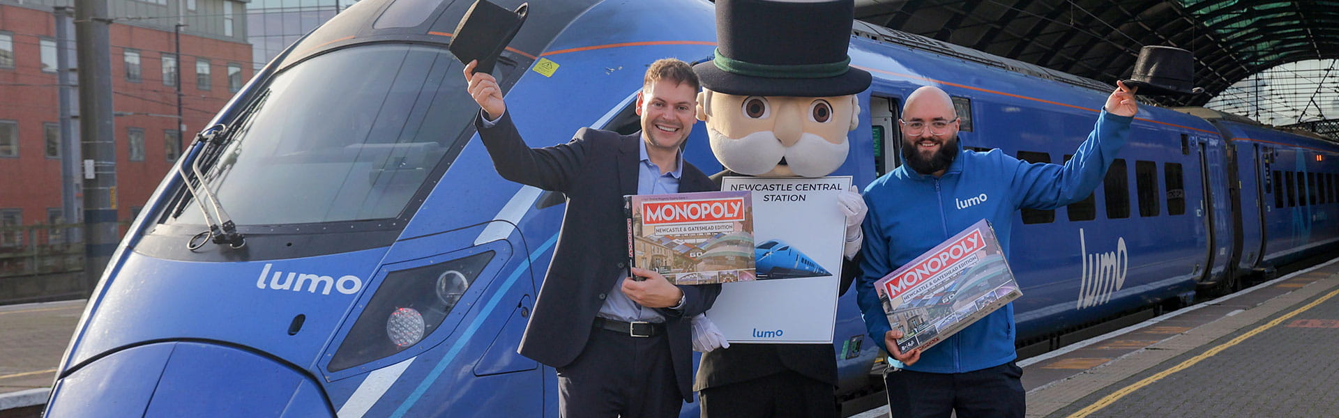 Martijn Gilbert, Managing Director of Lumo, and David Fox, Planning and Performance Manager at Lumo, posing next to Mr Monopoly at Newcastle Station