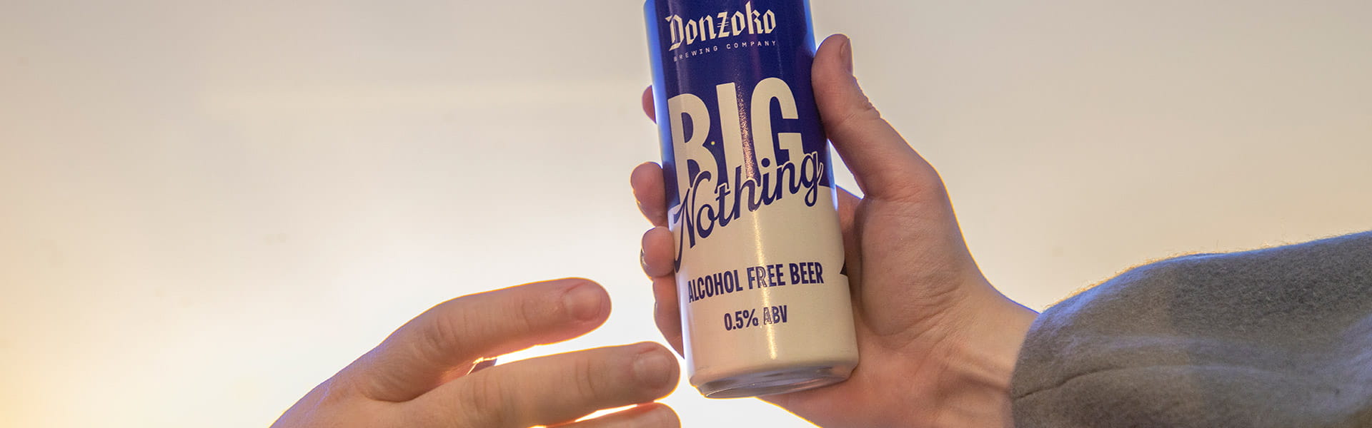 two hands holding the new low-calorie beer