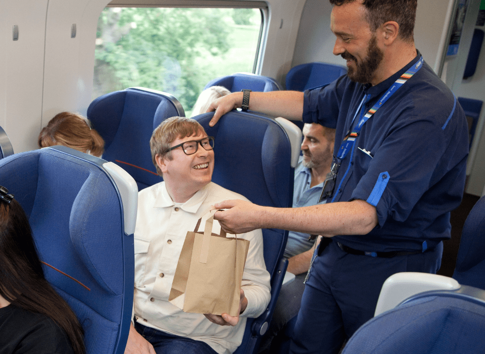 lumo staff handing passenger LumoEats food